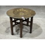 An Indian folding table with brass benares tray top.