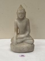 A carved hardstone Buddha seated on a rock. 12½" high.