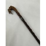 An Edward VII blackthorn walking cane, the pommel carved as a glass eyed hound's head with gamebird,