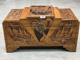 An Oriental camphorwood chest, carved in bas-relief. 24" wide.
