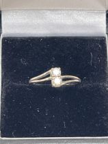 A 14ct white gold two stone diamond ring. 1.5g gross. Size K.