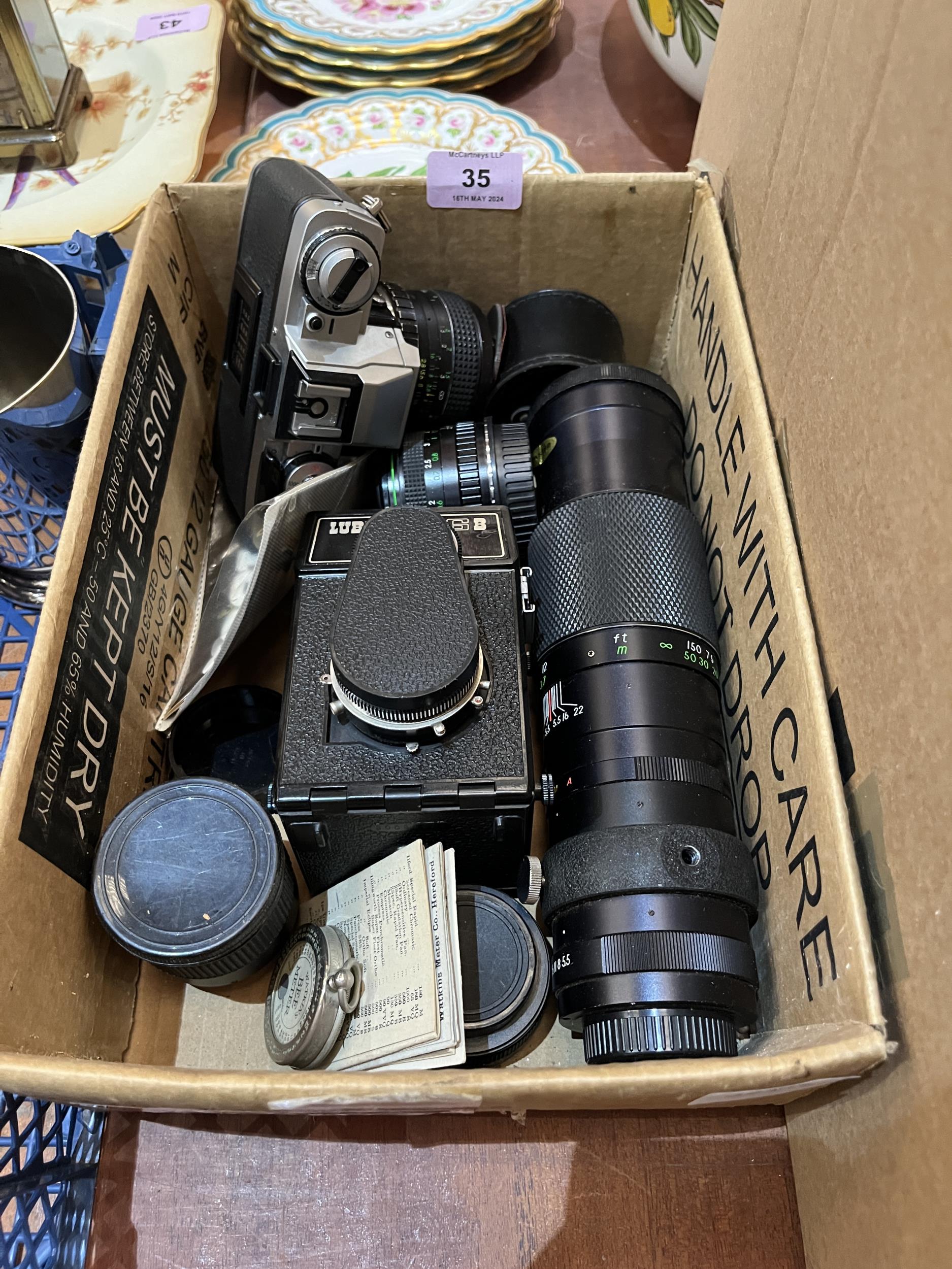 A Minolta XG-M 35mm camera, lenses and a Lubitell 166B camera.