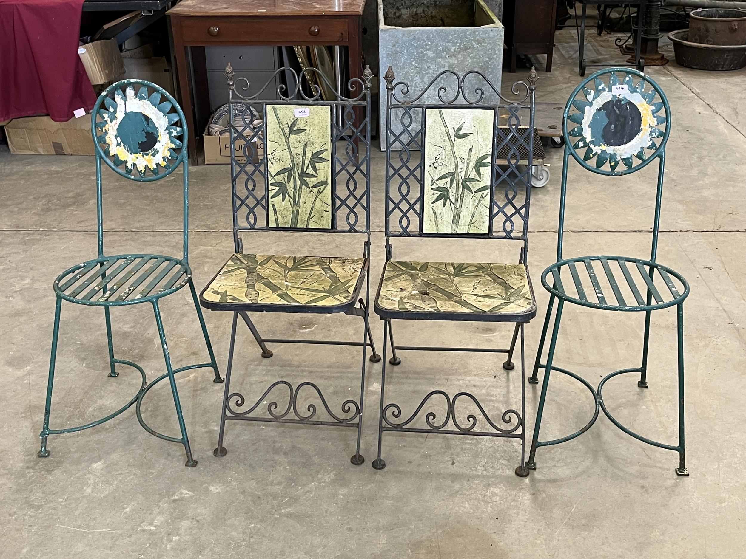 Two pairs of wrought iron patio chairs.