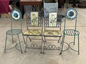 Two pairs of wrought iron patio chairs.