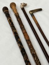 Four walking canes, one with silver collar.