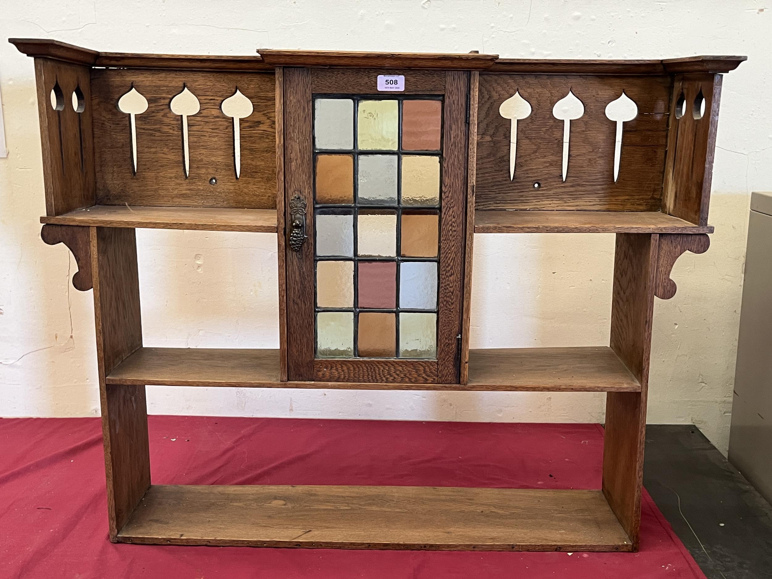 A set of oak Arts and Crafts hanging wall shelves in the manner of Liberty and Co, with cupboard