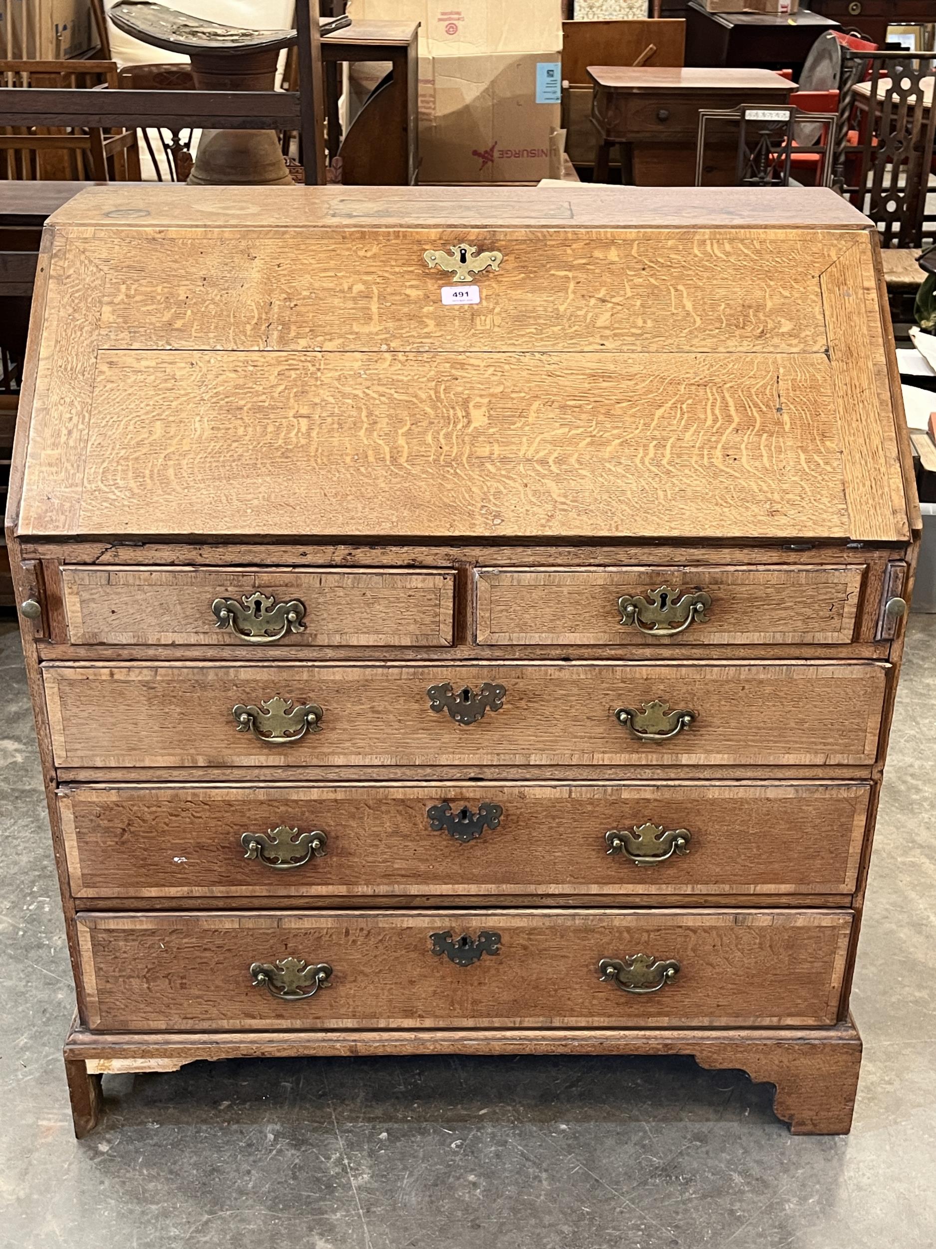 A George III oak and mahogany crossbanded bureau on bracket feet. 35" wide,