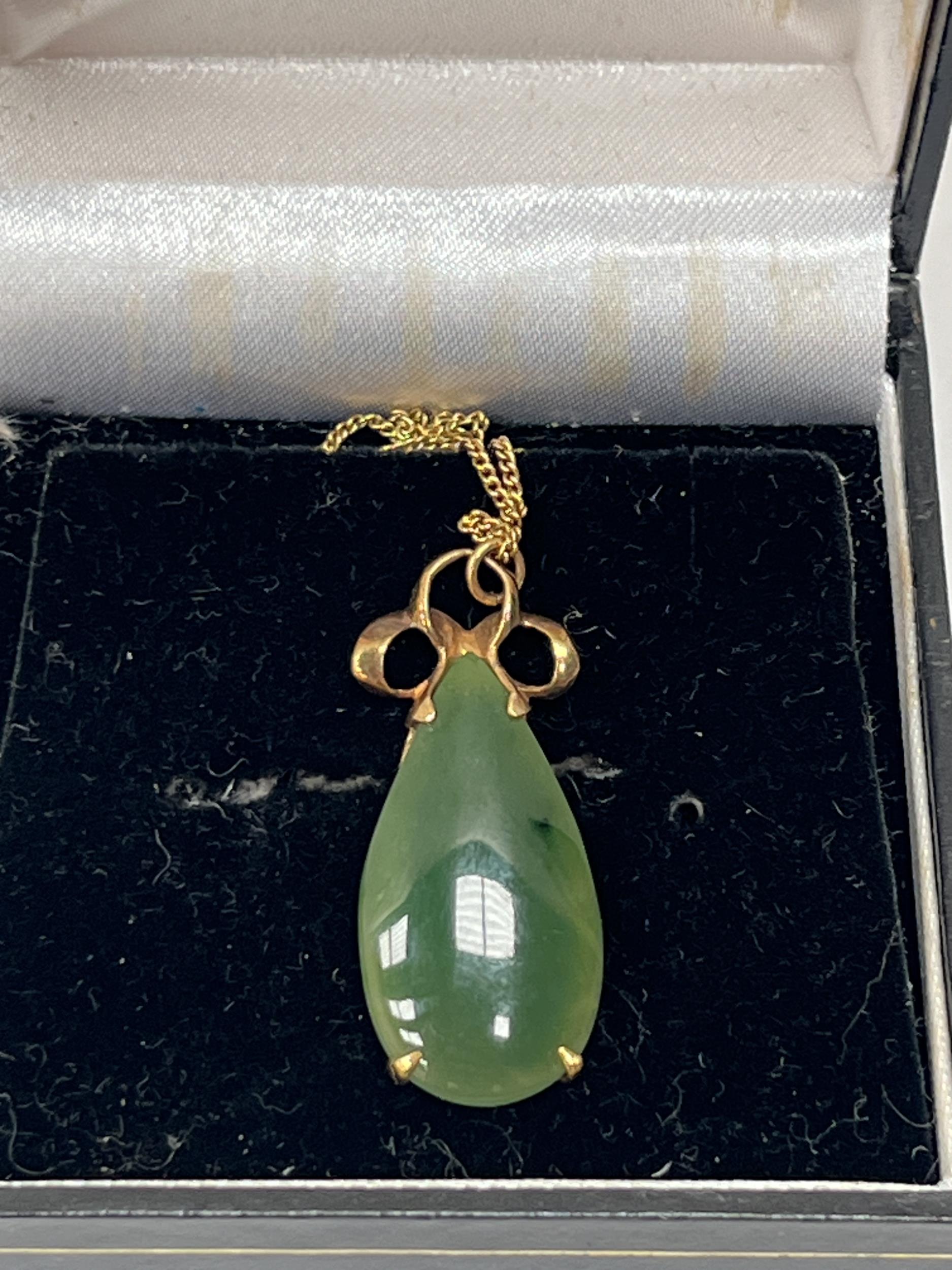 A 9ct jade pendant on necklet chain. 4.2g gross.