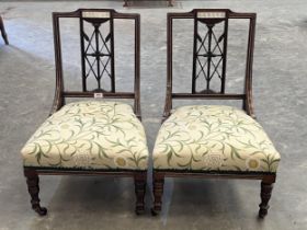 A pair of late Victorian rosewood and bone inlaid salon chairs.