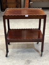 A mahogany two tier tea trolley.