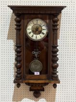 A Vienna style wall clock in walnut case, the two train movement striking on a coiled gong. 29"