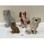 Four 19th Century Staffordshire glazed earthenware spaniels, the largest 10" high.