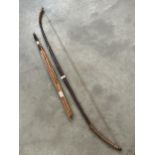 A treen longbow, 63" long, with eight spear tip arrows.