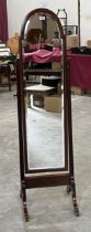 An Edward VII mahogany cheval dressing glass with break-arch bevelled plate. 60" high.