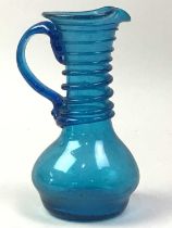 TWO BLUE CLUTHA GLASS JUGS, ALONG WITH OTHER GLASSWARE