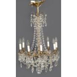 A glass chandelier, late 20th c, of eight lights, on scrolling giltmetal branches and festooned with