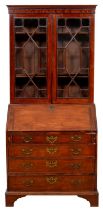 A George III mahogany bureau, the associated bookcase with dentil cornice above adjustable shelves