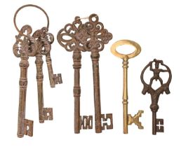 Six decorative iron keys and a brass example, 45cm and shorter