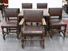 An oak draw leaf table and set of seven carolean style oak dining chairs, including an elbow chair