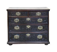 A George III oak chest of drawers, panelled sides, the drawer fronts carved in the 19th c, pierced