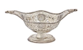An Edwardian pierced silver fruit bowl, with cast handles and beaded rim, the sides inset with