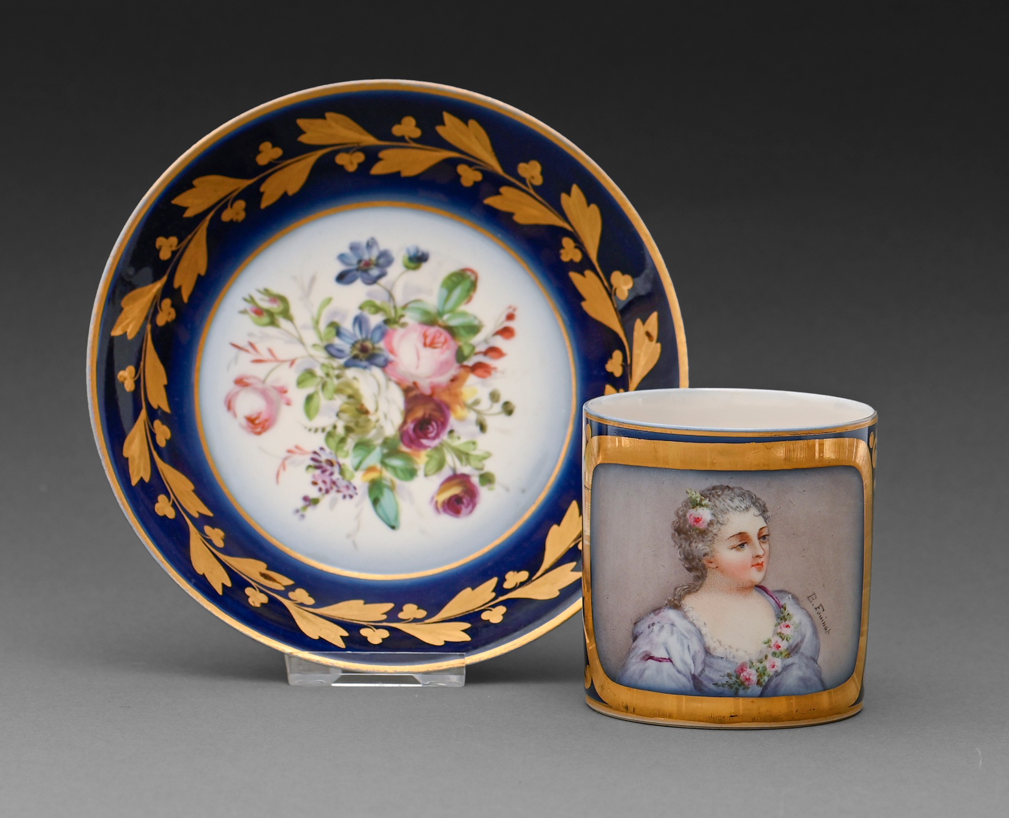 A French porcelain coffee can and a saucer, early 20th c, painted with a portrait of a young