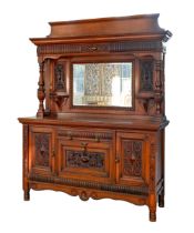 An Edwardian oak sideboard, with bevelled mirror to the canopied back, substantial brass drop