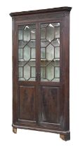 A George III mahogany standing corner cupboard, with dentil cornice and blind fret frieze, the upper