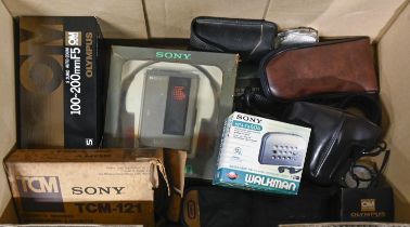 A Sony Walkman WM-7, c1982, silver with headphones, boxed, another Walkman, boxed, an Olympus OM2