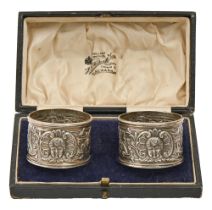 A pair of Victorian silver rococo revival napkin rings, decorated with mask, by The Goldsmiths &