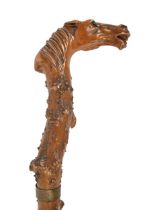 A gnarled wood cane, c1900, the handle carved with the head of a horse with glass eyes, steel and