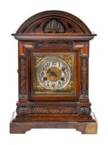 A German carved oak arch top bracket clock, c1930, with brass and silvered dial, pendulum and key,
