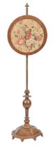 A Victorian brass pole screen, on turned wood base with associated round floral woolwork banner,