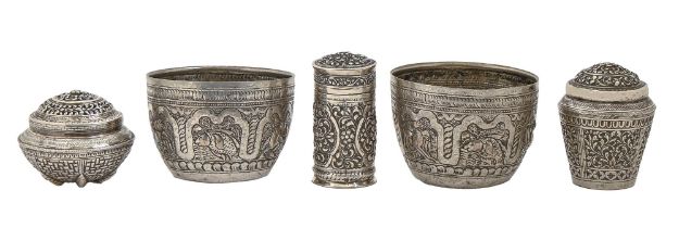 A South East Asian silver repousse canister and cover, two other covered vessels and a pair of