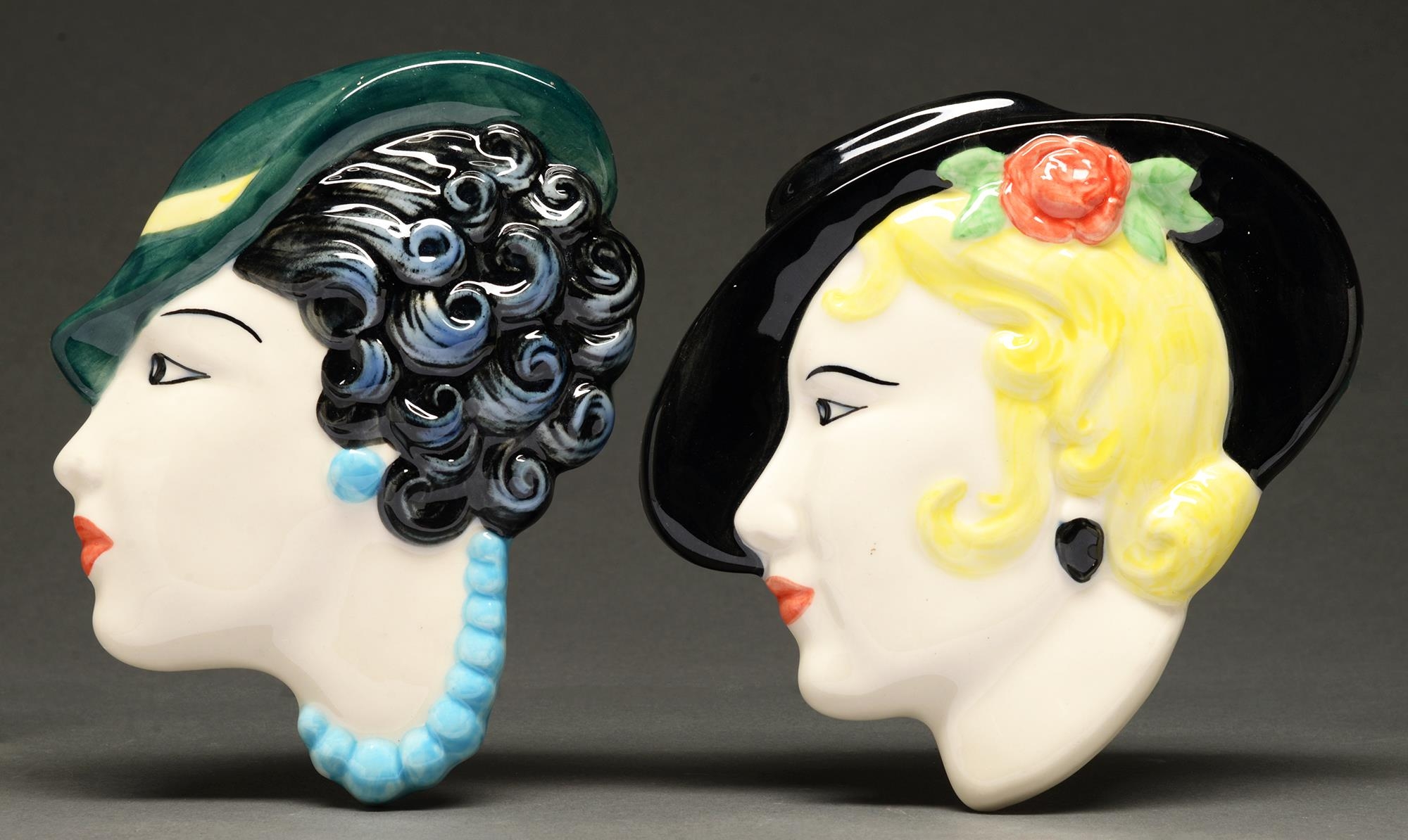 Two slip cast earthenware wall heads, each as a stylish young woman in a hat, in Art Deco style,