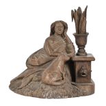 A Black Forest type limewood carving of a seated lady and her cat by a fountain, early 20th c,