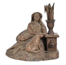 A Black Forest type limewood carving of a seated lady and her cat by a fountain, early 20th c,