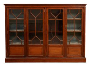 An Edwardian mahogany bookcase, fitted with adjustable shelves enclosed by four glazed doors, the