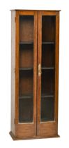 An oak bookcase, with full height glazed doors, adapted from a gun cabinet, 131cm h; 25 x 48cm