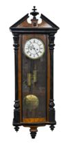 A stained and black painted walnut Vienna wall clock, c1930, brass and enamel dial, pendulum,