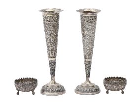 A pair of South East Asian silver repousse vases and pair of salt cellars, c1900, vase 17.5cm h,