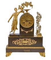 A Charles X gilt and patinated bronze mantel clock, the dial set in a pillar flanked by bacchante