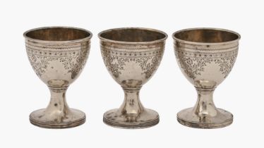 A set of three George III bright cut silver eggcups, engraved with flowers, 68mm h, by Stephen