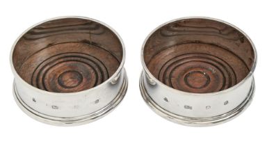 A pair of Elizabeth II silver wine coasters, inset turned wood base, 96mm diam, by M C Hersey &