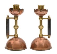 A pair of Victorian aesthetic style brass and copper hand candlesticks in the manner of Dr