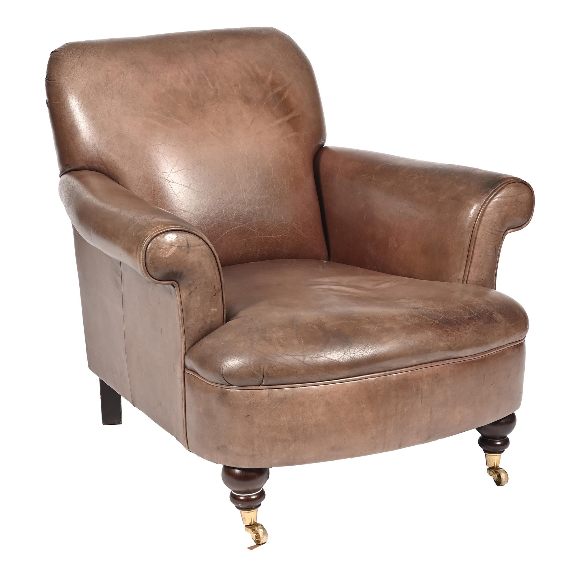 A mid 20th c brown leather armchair, turned mahogany front legs on brass castors, seat height