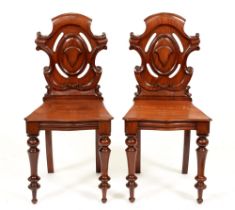A pair of Victorian carved mahogany hall chairs, pierced splat, on turned front legs Good clean