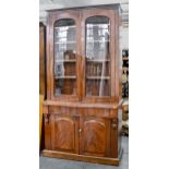 A Victorian mahogany bookcase, the upper part enclosed by glazed doors with adjustable shelves, on