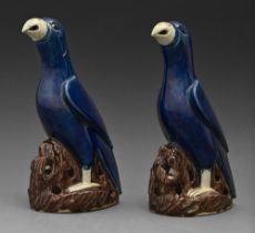 A pair of Chinese blue and aubergine glazed porcelain models of parrots, 19th c , on pierced