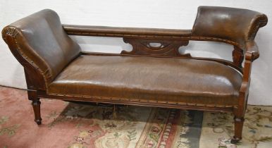 A Victorian carved mahogany couch, covered with nailed back brown leather, on turned legs and